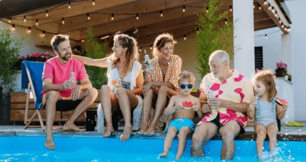 Happy family by pool wearing colorful summer swimwear line pieces enjoying vacation together