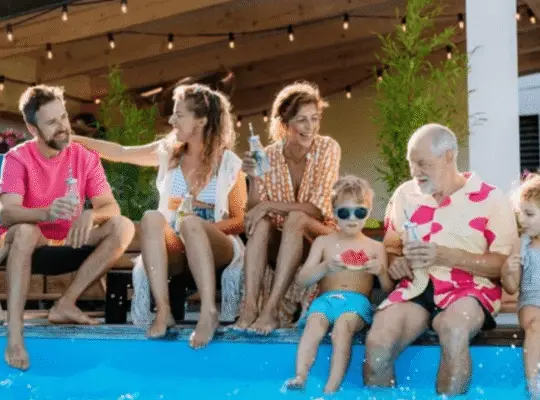 Happy family by pool wearing colorful summer swimwear line pieces enjoying vacation together