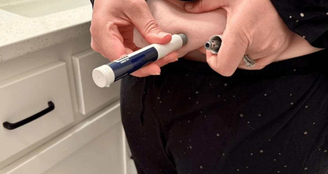 Person preparing GLP-1 weight loss injection pen medication for weekly self-administration