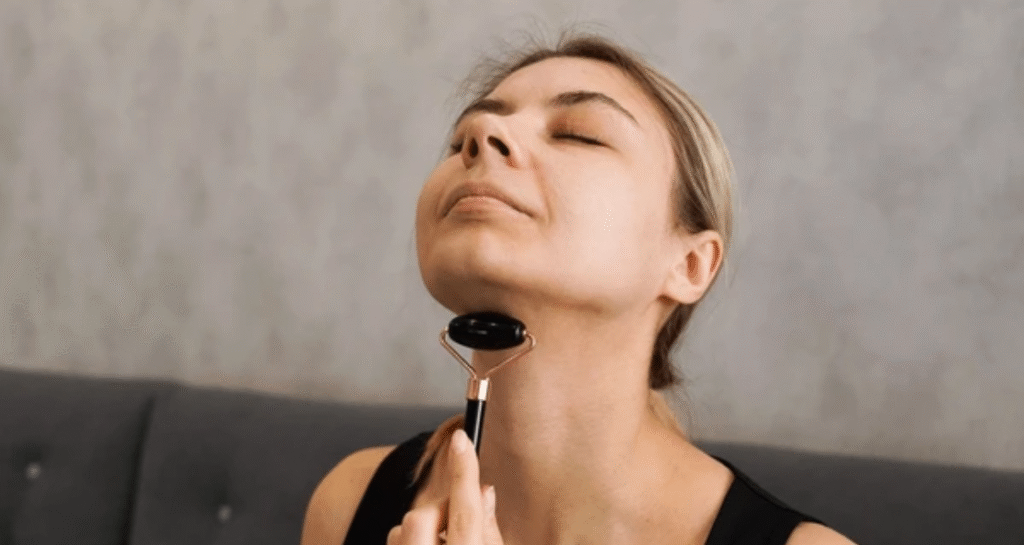 Woman using facial massage tool on neck area for wrinkles reduction exercise routine