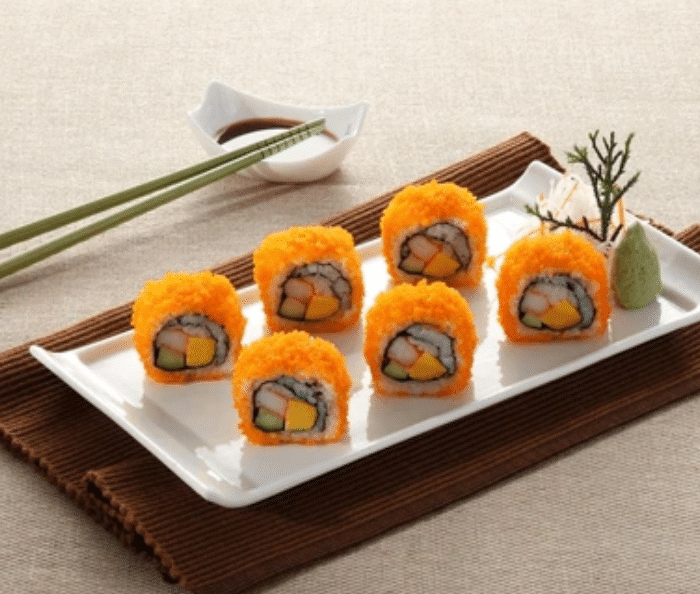 Fresh masago capelin fish roe sushi rolls with orange coating served on white plate showcasing vibrant flavor and texture