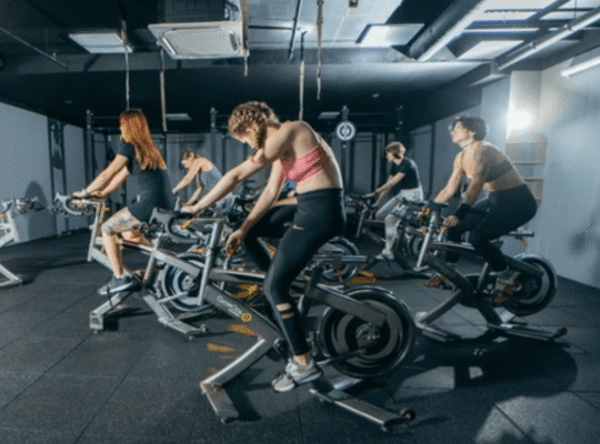 Group fitness class using spin bike equipment during intensive training session covering miles of indoor cycling