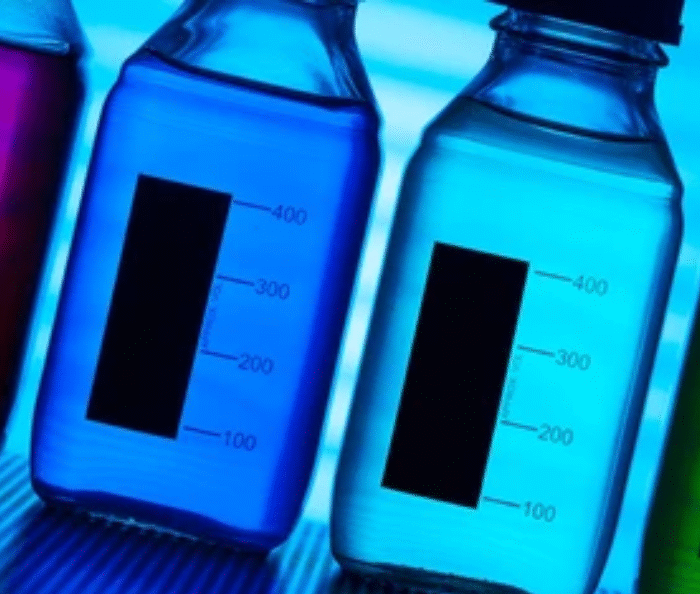 Colorful synthetic food dyes and additives in laboratory bottles showing artificial colors used in processed foods
