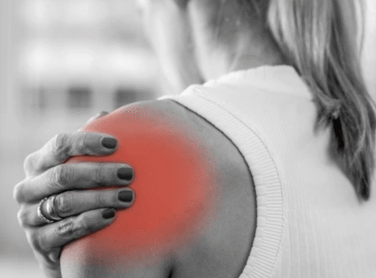 Woman experiencing shoulder pain holding inflamed area highlighted in red showing common joint injury and discomfort